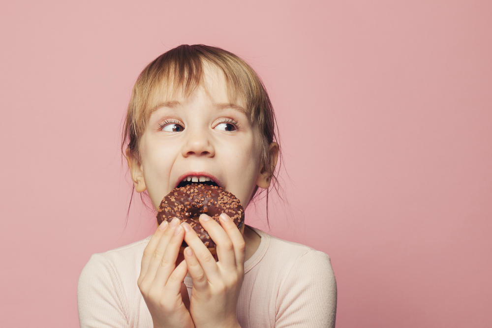 Funny,Little,Child,Girl,With,Donut.,On,Pink,Background