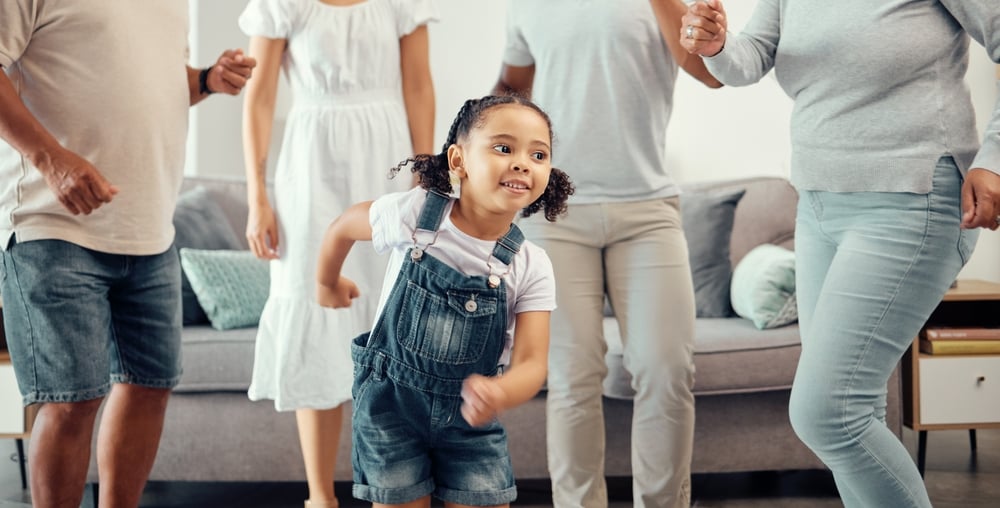 Cute girl dancing surrounded by family