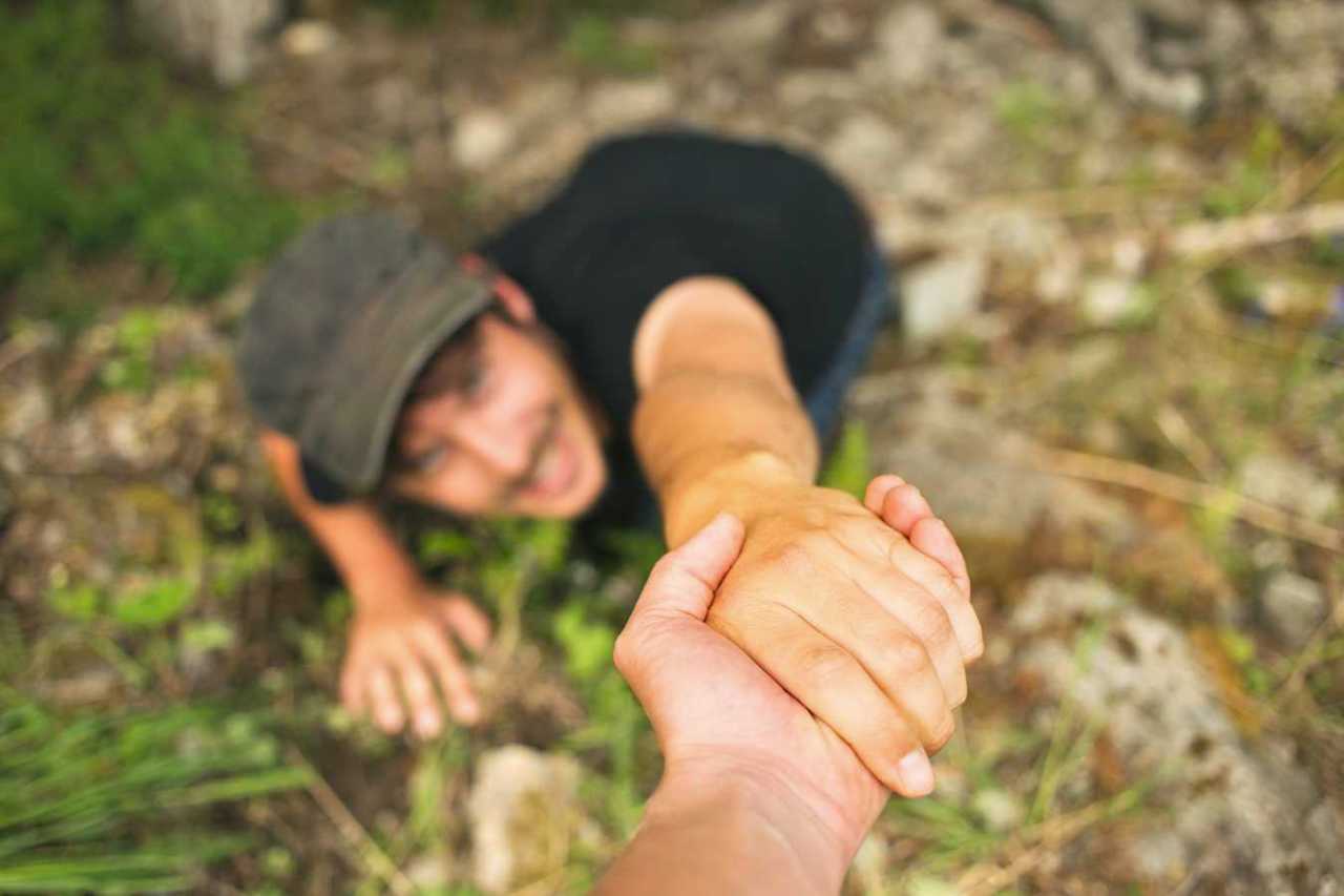 Hand helping a man to raise after falling.