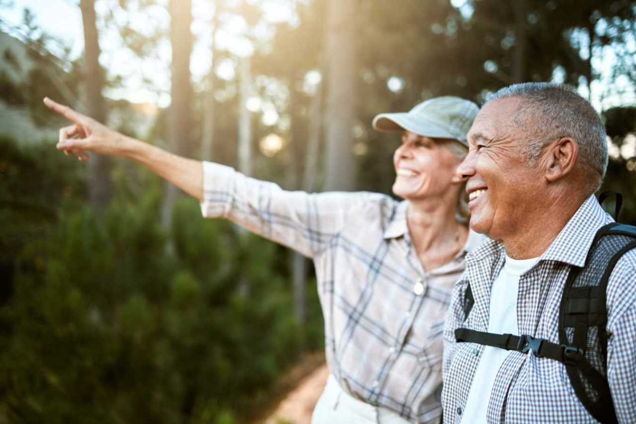 A happy senior couple enjoying the adventure of a hike together.