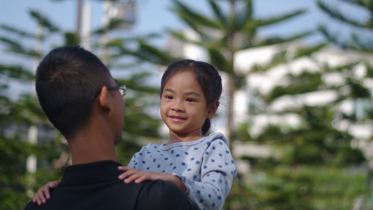 Father holds smiling child.