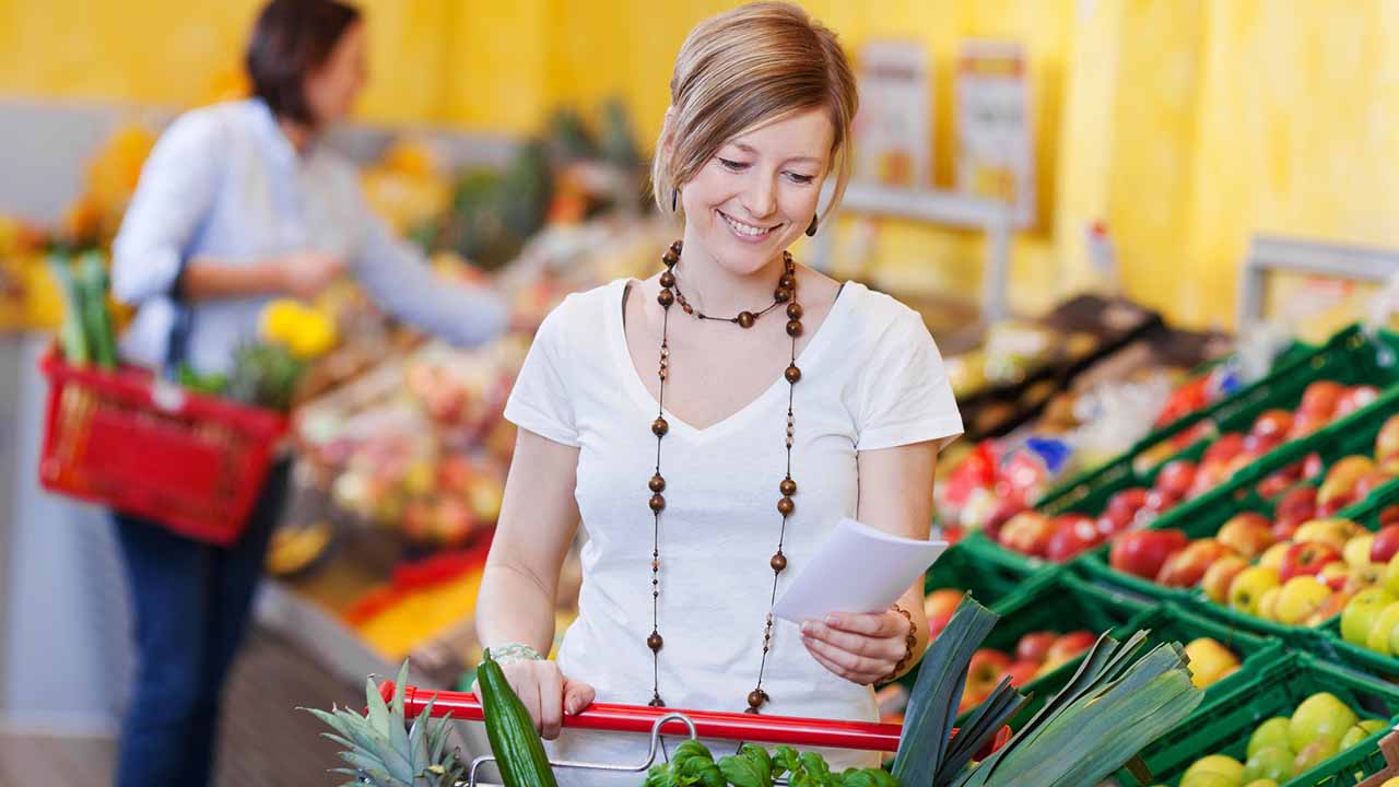 Person shopping for food using grocery list.