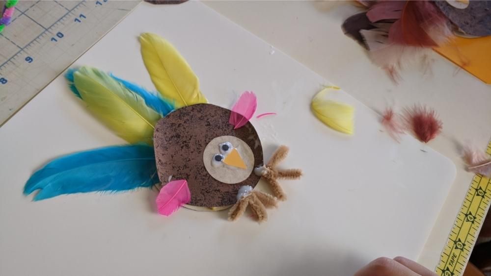 Image of a glue and paper turkey with feathers around it