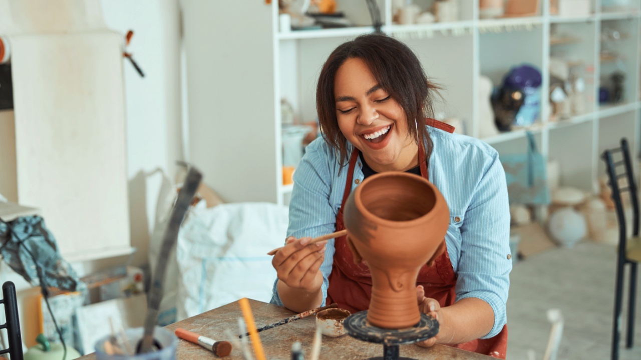 Smiling woman happy working in a pottery studio.